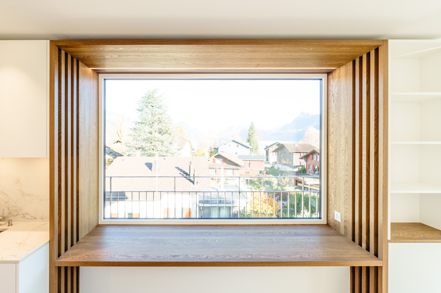 Sitzfenster aus Eichenholz mit Blick auf Balkon und Nachbarhäuser